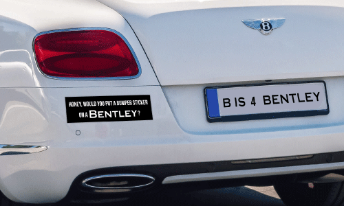 White Bentley sedan with a black and white bumper sticker that says Honey, Would You  Put a Bumper Sticker on a Bentley? License plats reads B Is For Bentley.
