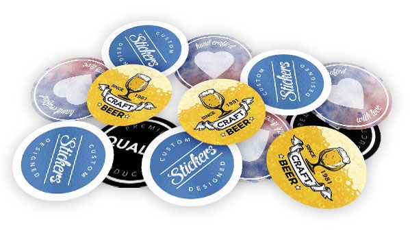 Multiple stickers in a pile on a white background. They include heart stickers, brewery advertisement stickers in yellow with a black outlined glass, and blue stickers that say custom stickers designed in white lettering and black stickers with white text that says quality.