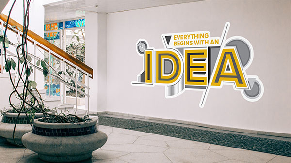 Wall letter decal with yellow text that says everything begins with an and then black text outlined in yellow saying Idea.